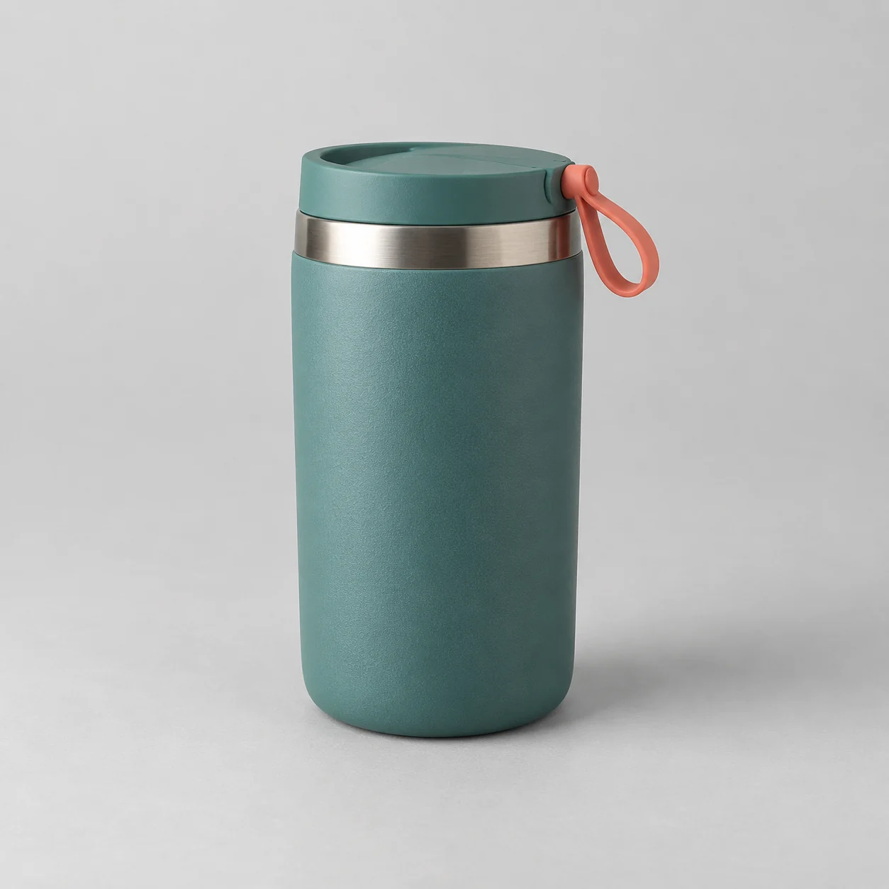 Synthetic reference: matte teal travel mug with a steel rim and coral loop on a gray studio surface